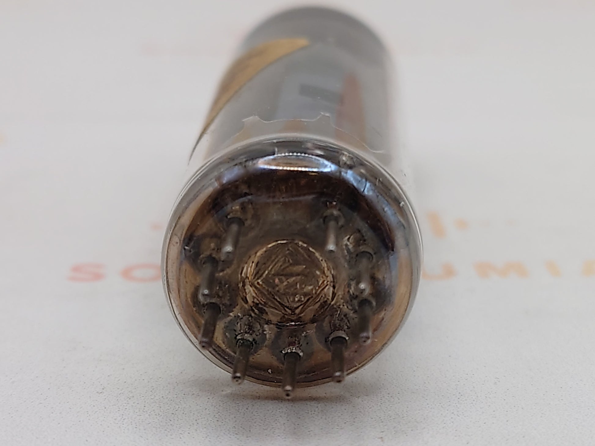 Close-up of a metallic cylindrical object with intricate design on a light gray background